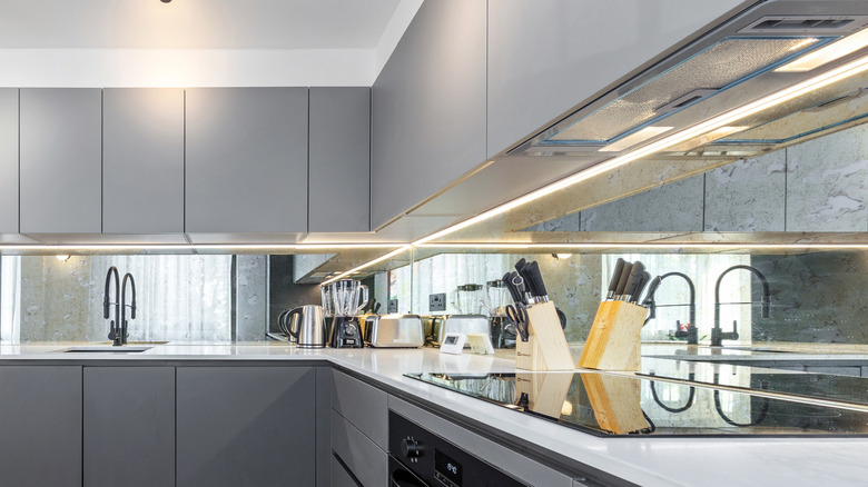 Modern kitchen with glass panel backsplash.