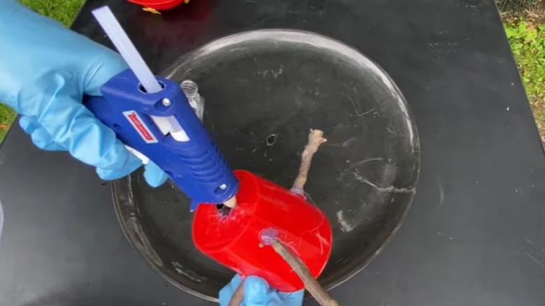 Creator hot gluing nozzle to base of mug