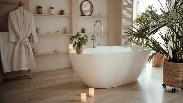 A spa-inspired bathroom with a tub and bathrobe hanging