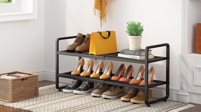 SNTD expandable shoe rack with shoes, books, plant, and bag sitting on it in an entryway.