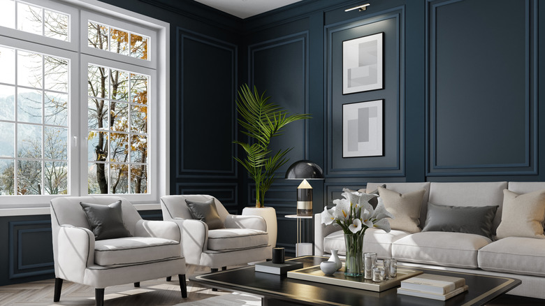 Living room with dark navy blue walls and white trim.