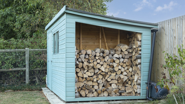 Large blue shed filled with firewood