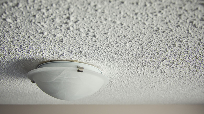Closeup of a painted popcorn ceiling with a light fixture