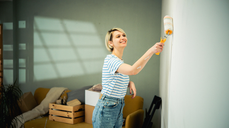 Woman painting walls.