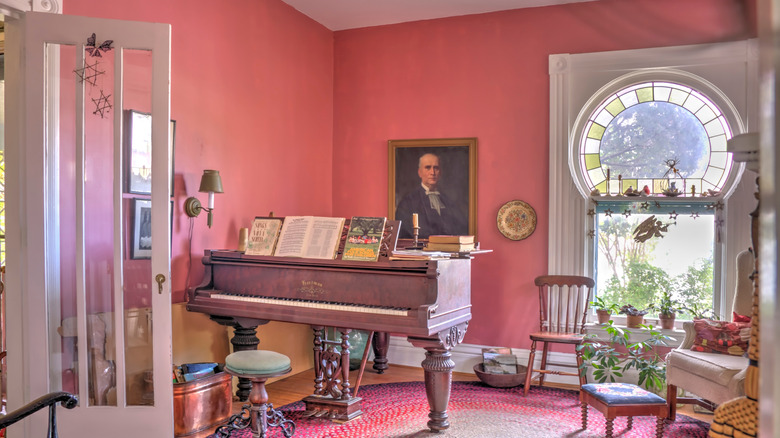 Sunny room with piano and rose pink walls.