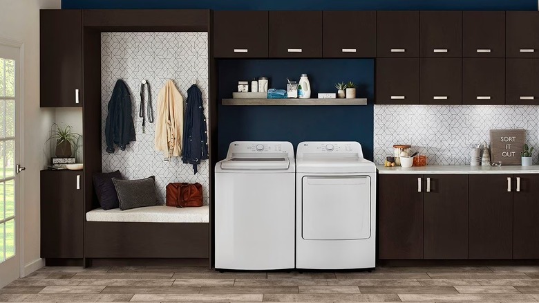 White washer and dryer sitting next to each other in a small laundry space