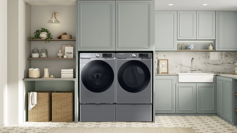 Stainless steel washer and dryer sitting side-by-side in a laundry room