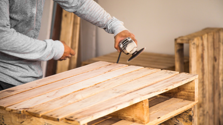 Forklift picking up a stack of wooden pallets