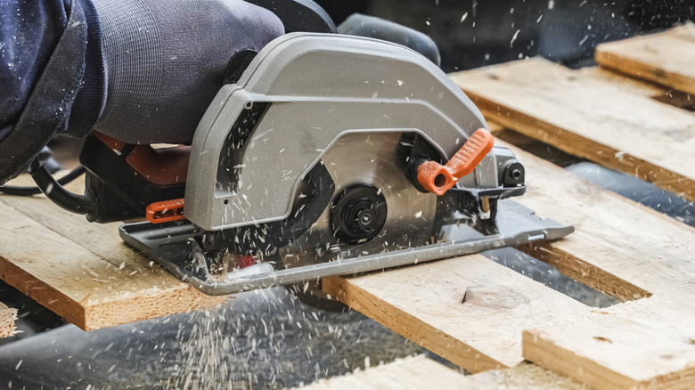 Using a circular saw to cut up scrap wood pallets