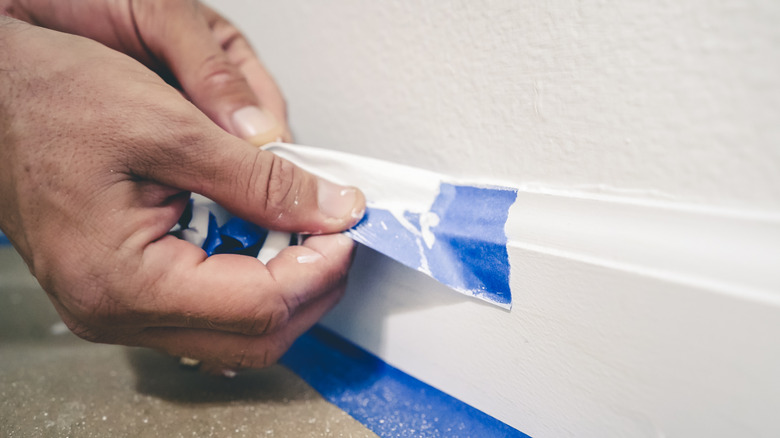 Person peeling back painter's tape