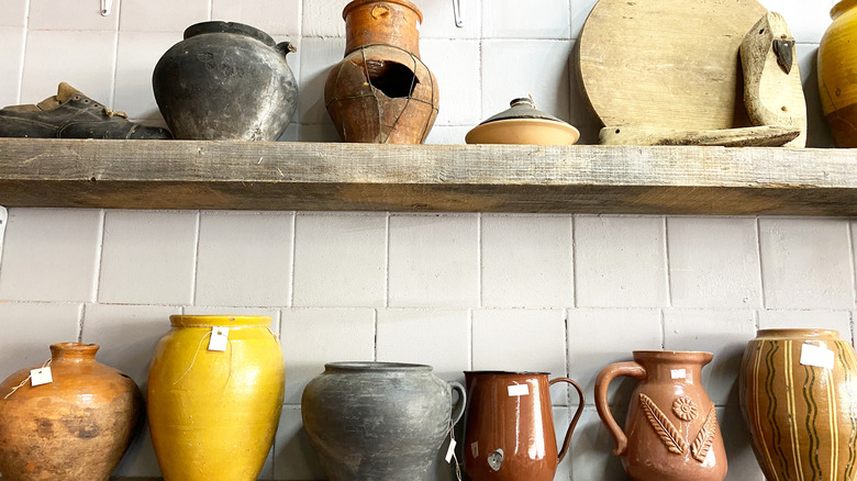 Assorted pottery, dishware, and glassware on a shelf.
