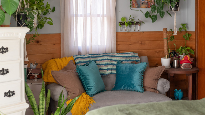 A small living room sporting warm-toned decor and trailing houseplants