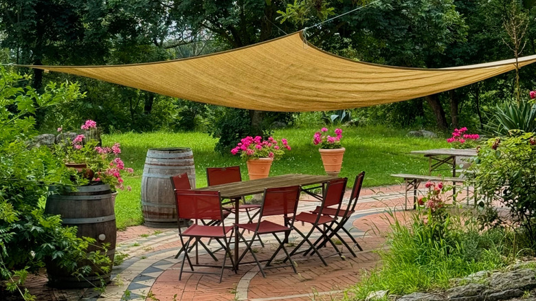 A yellow shade sail covering an outdoor seating area