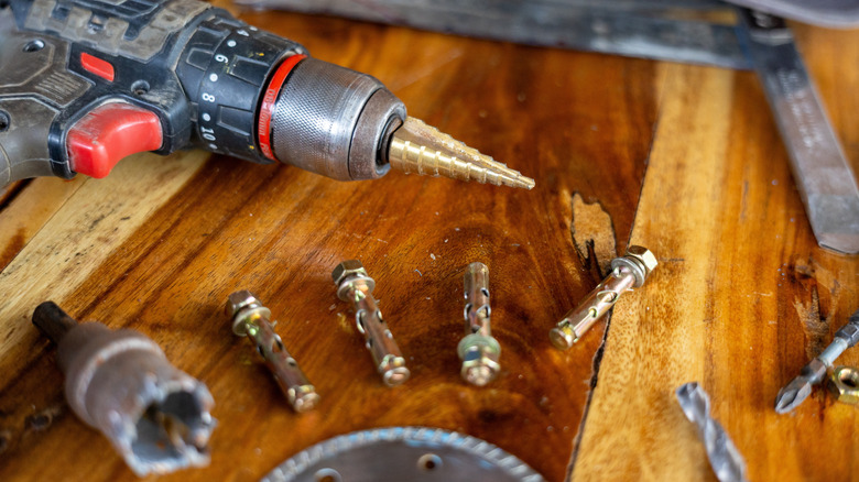 A cordless drill and assorted drill bits
