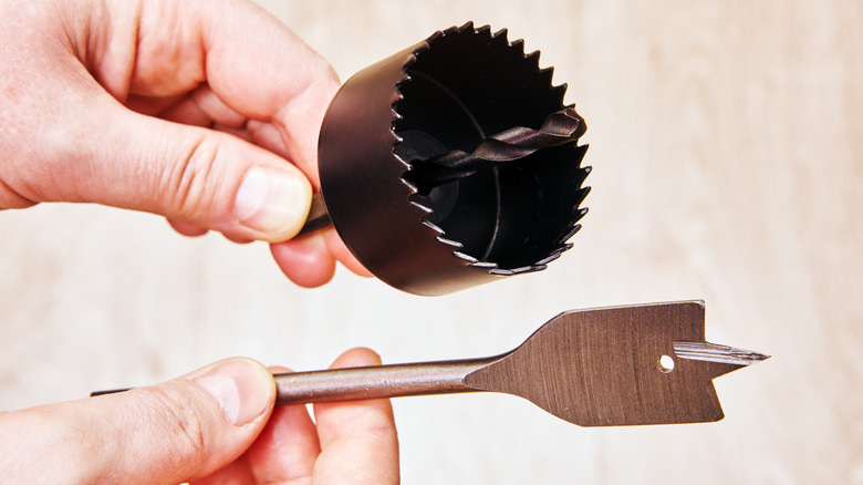 A hole saw and a spade bit showing the different cutting edges