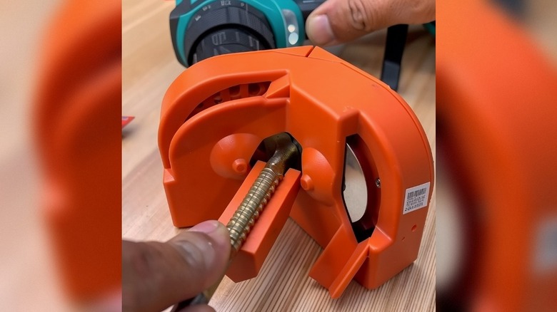 A person using a BUXUNA portable drill-bit sharpener on a drill