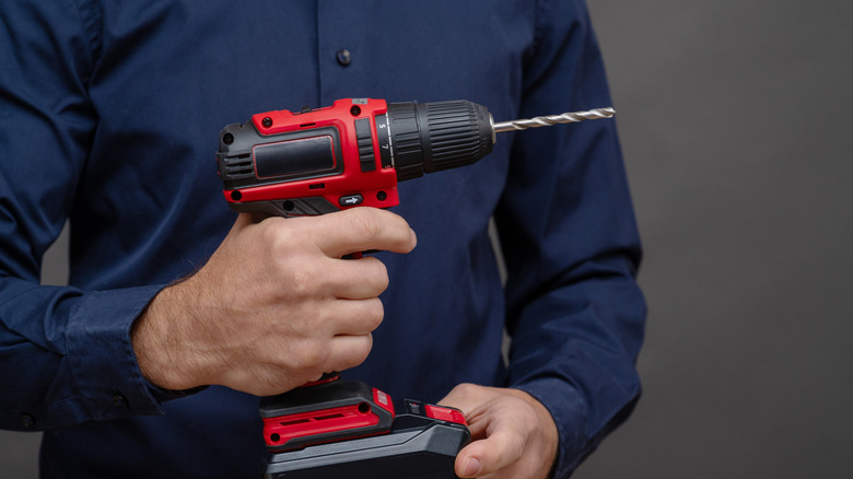 A person holding a wireless power drill