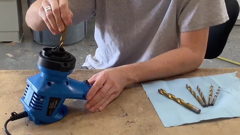 A person using the MDPSDS portable drill bit sharpener