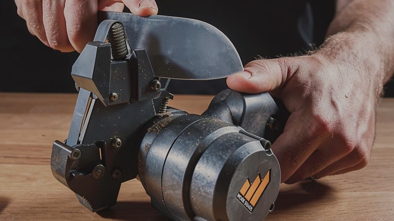 a person using the Work Sharp knife and tool sharpener Mark 2 to sharpen a knife