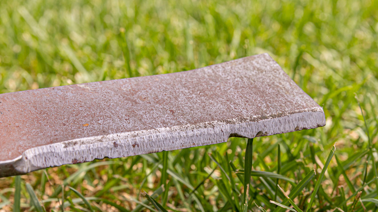 a rusty and dull lawn mower blade