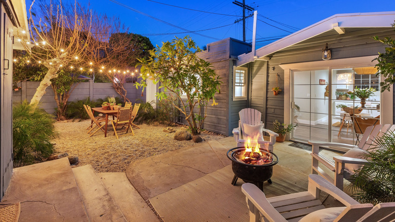 A cozy backyard with string lights and wooden deck chairs