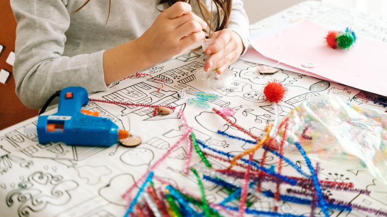 Making crafts with pipe cleaners and hot glue.