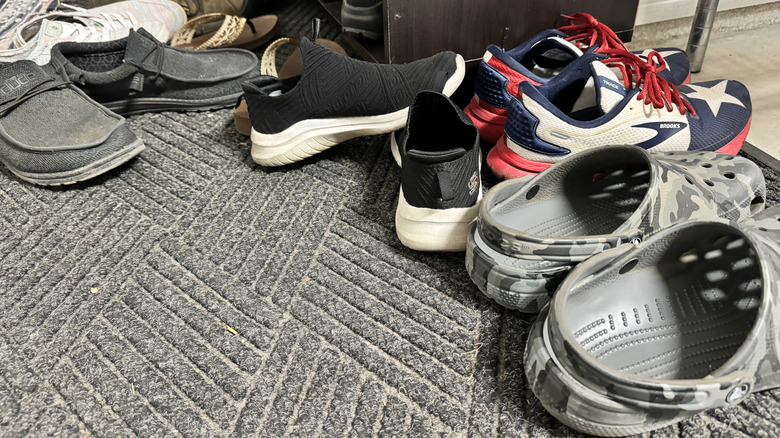 A pile of shoes on a gray carpet