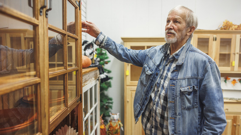 A man looking at vintage furniture at a thrift store