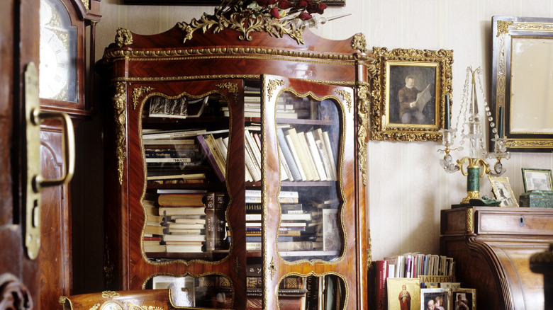 A vintage bookcase surrounded by antiques