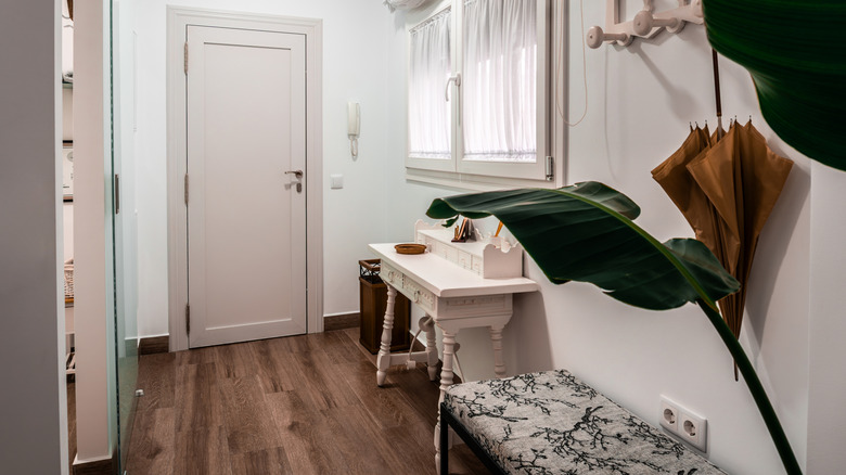 woman helping boy put shoes on while sitting on staircase in entryway