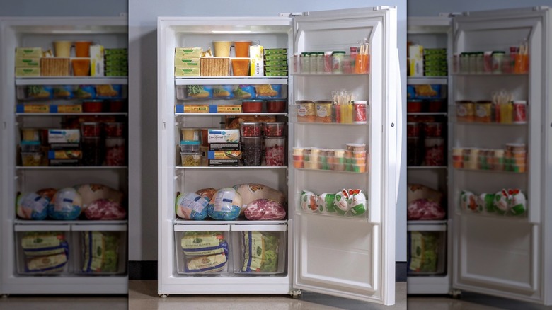 A stocked upright freezer with its door open