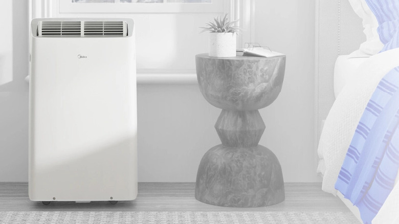 A portable air conditioner sitting in a bedroom