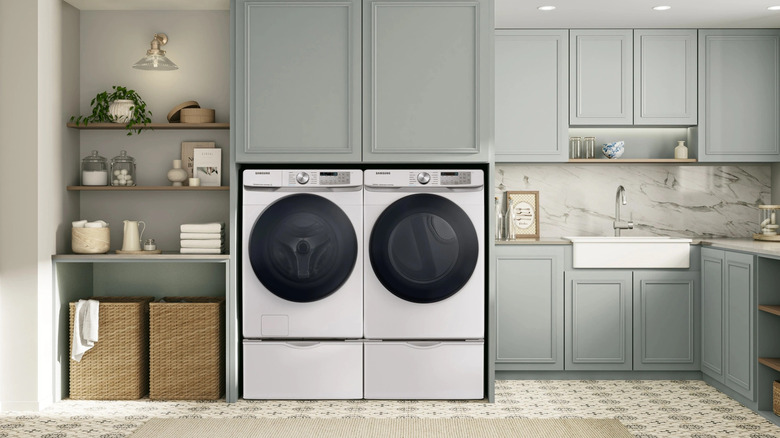 A washer and dryer next to each other in a large laundry room space