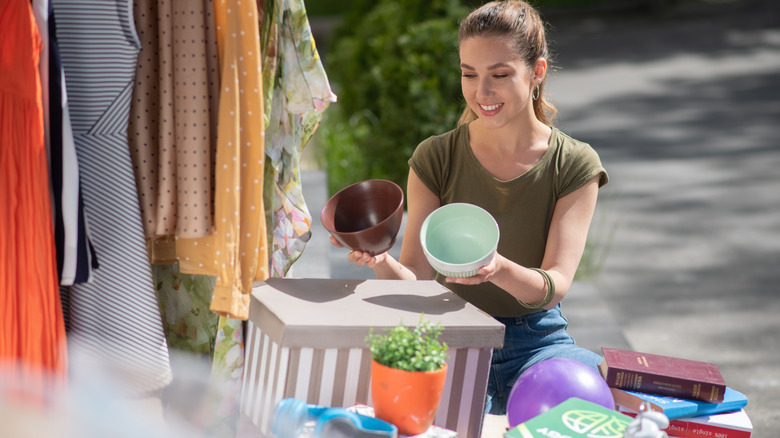 Woman holding and comparing two items at a garage sale