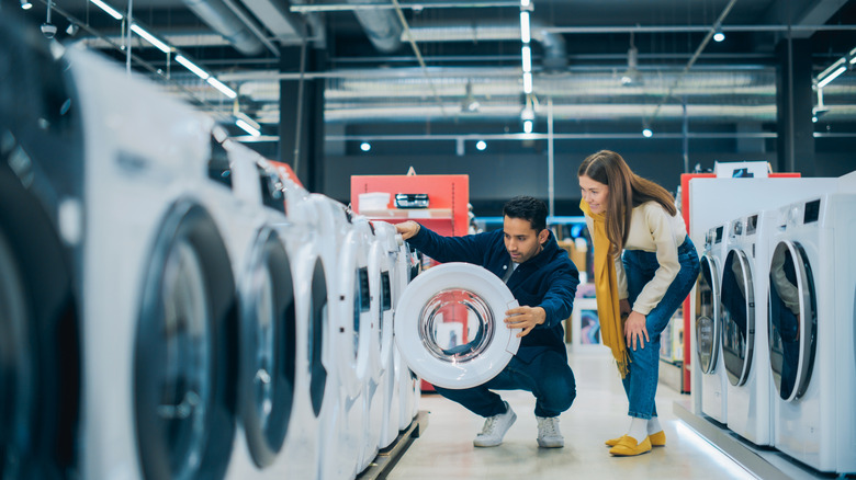 Couple looking at washing machine models on a sales floor