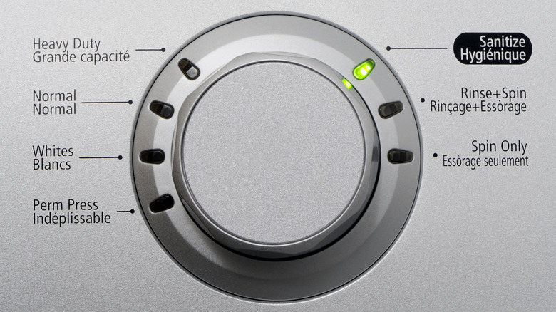 Washer dial with cycle options and green light on sanitize