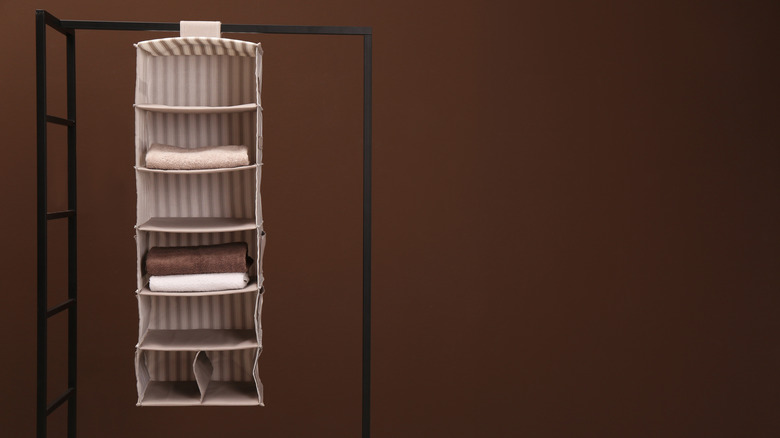 A striped fabric shelf hanging on a metal rack.