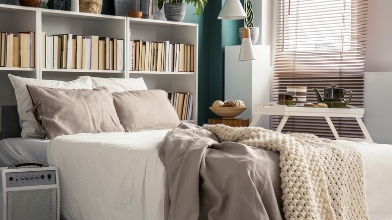 Bookshelves being used as a headboard in a bedroom.