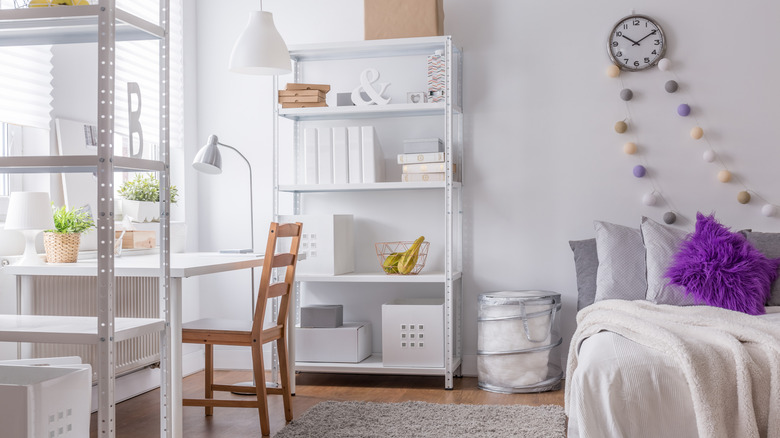 Interior of a bedroom with free-standing shelves.