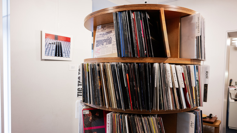 Rotating circular wooden shelf displaying vinyl record collection organized in a room interior.