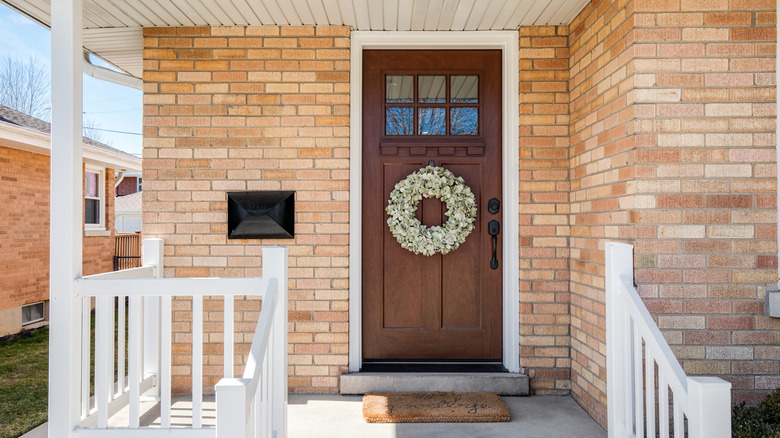 A wreath hanging below dentil shelf on door