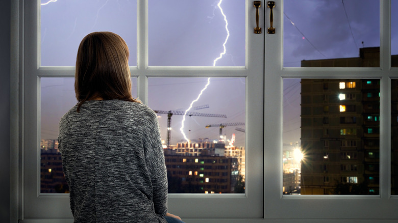 Girl watching a lightning storm