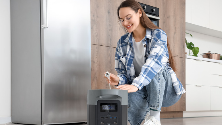 Woman connecting a fridge to a portable power station