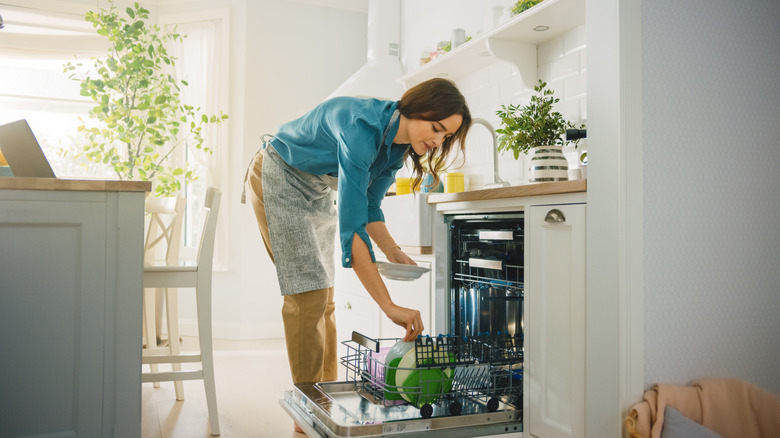 maid loading dishwasher