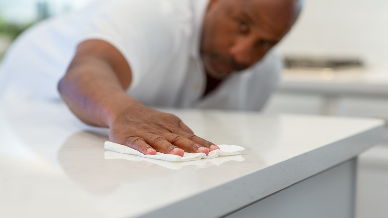 Man wiping down quartz countertop