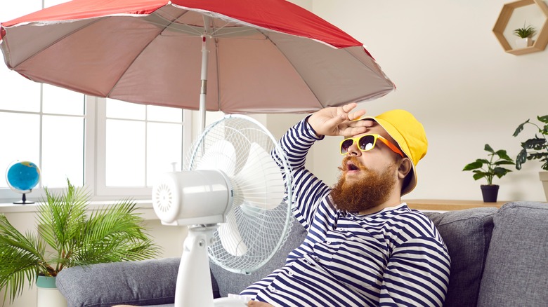 man in apartment with fan