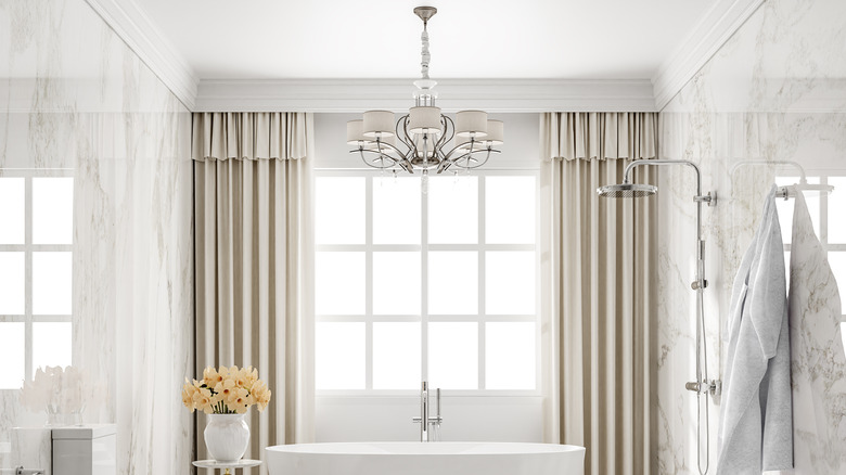 White and gray chandelier over a tub