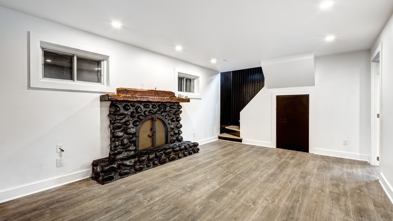 Image of a finished basement with a stone fireplace