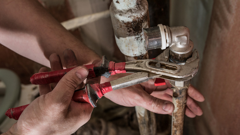 A plumber replaces a rusty, old pipe