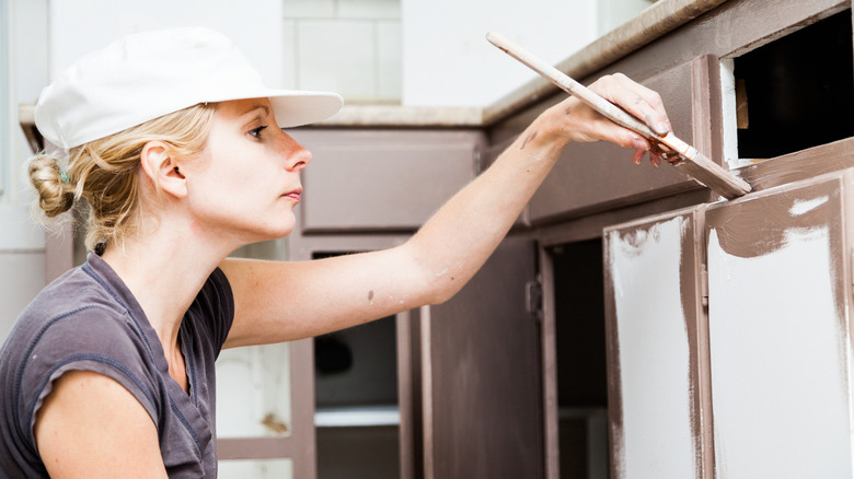 woman painting cabinet